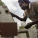 Community member using a hand pump in Sierra Leone — UNDP inclusive growth programme photo