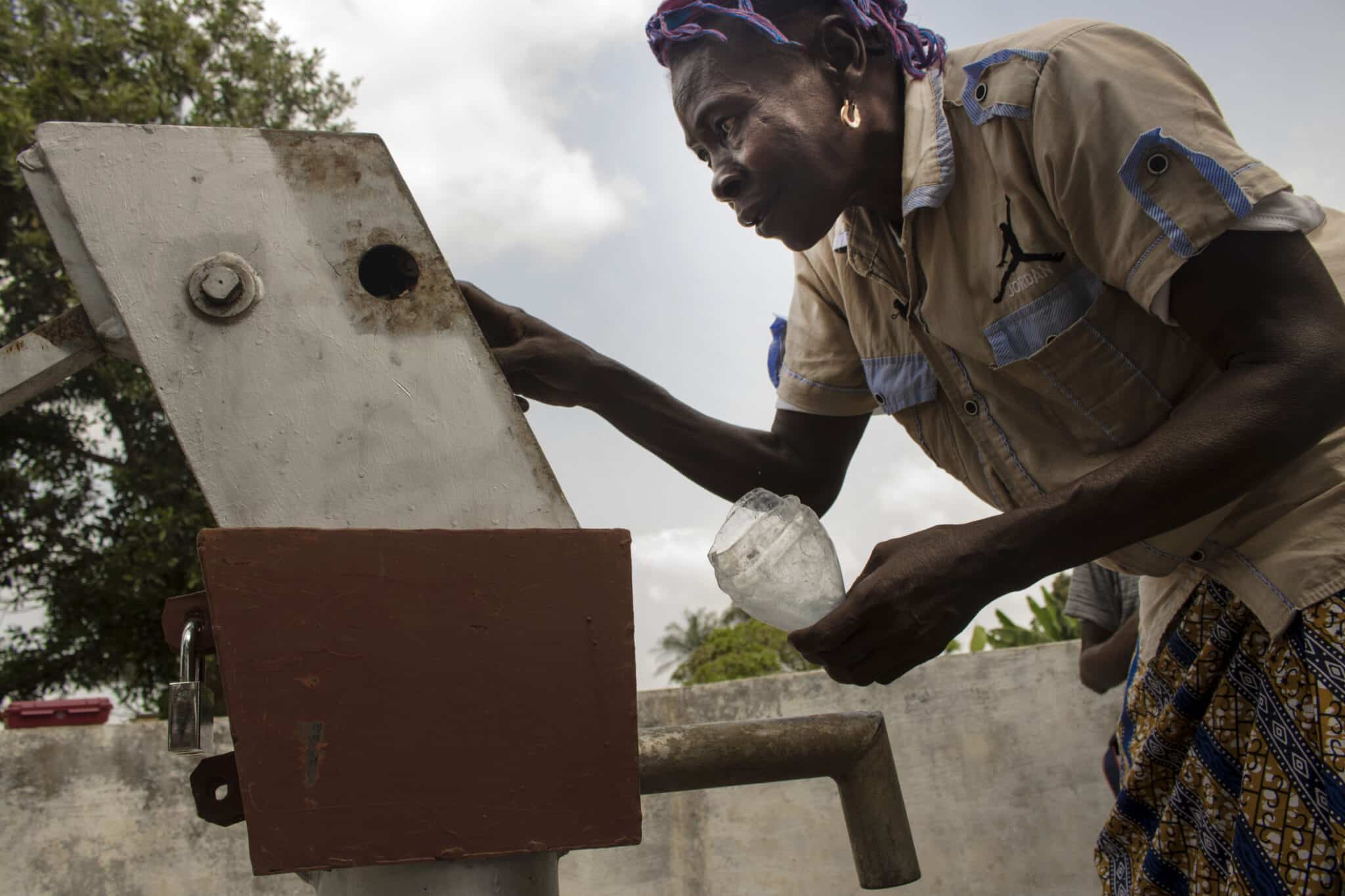 Community member using a hand pump in Sierra Leone — UNDP inclusive growth programme photo