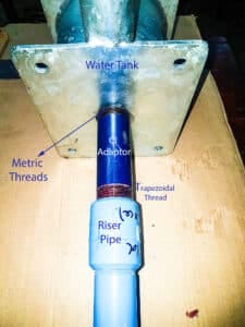 Labeled diagram of a PVC riser pipe connecting to the pump's water tank via a metric-to-square thread adaptor